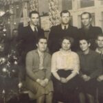 Fotografia rodziny, która siedzi po prawej stronie świątecznej choinki.