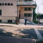 Fotografia przedstawia główne wejście do budynku biblioteki. Widoczny baner: 50 lat Miejskiej Biblioteki Publicznej w Chrzanowie.