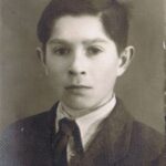 Fotografia przedstawia portret chłopca w garniturze.