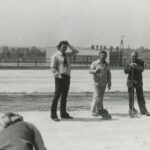 Fotografia przedstawia dwóch mężczyzn z łopatami oraz mężczyznę w białej koszuli drapiącego się po głowie.