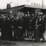 Fotografia przedstawia grupę ludzi stojących obok autobusu AUTOSAN. W tle widoczny budynek dworca autobusowego z napisem „Chrzanów”.