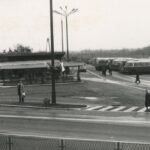 Fotografia przedstawia widok na dworzec autobusowy z napisem "Chrzanów". Widoczne wiaty przystrojone flagami narodowymi oraz autobusy na stanowiskach.
