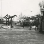 Fotografia przedstawia szkielety stawianych wiat autobusowych. Widoczni przechodzący przez plac ludzie.