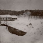 Fotografia przedstawia teren zakładu wydobywczego w zimie. Na pierwszym planie puste wagoniki.