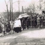 Fotografia przedstawia orszak pogrzebowy, na czele dzieci niosą wieńce.