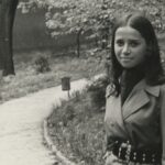 Fotografia przedstawia młodą kobietę w parku.