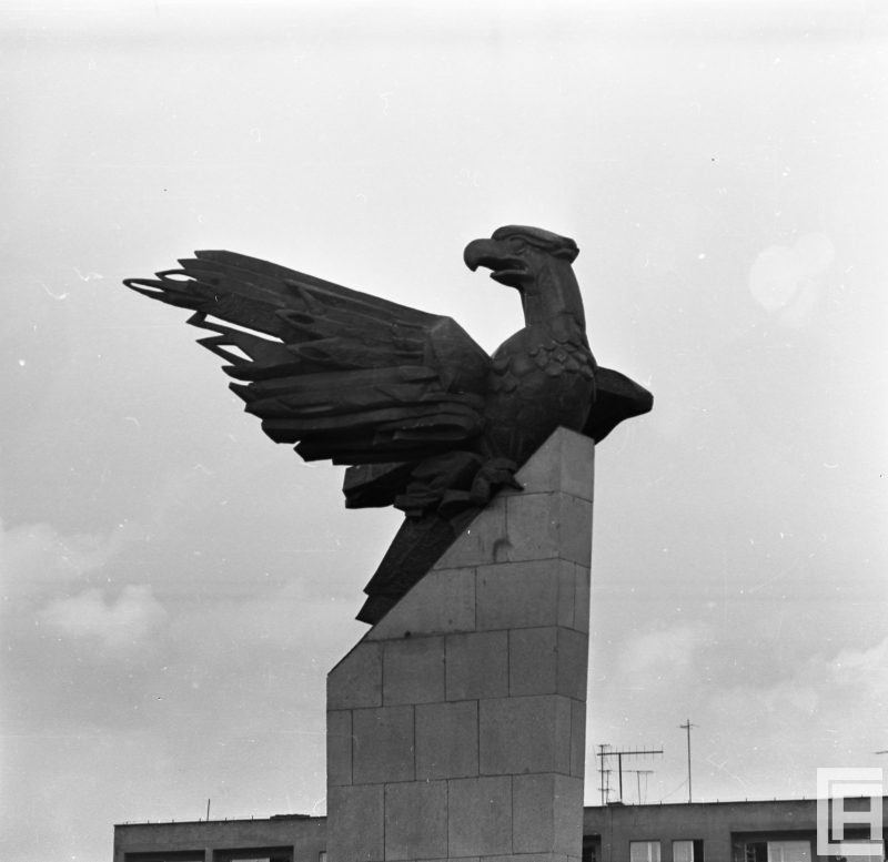 Fotografia przedstawia zbliżenie rzeźby orła na pomniku.